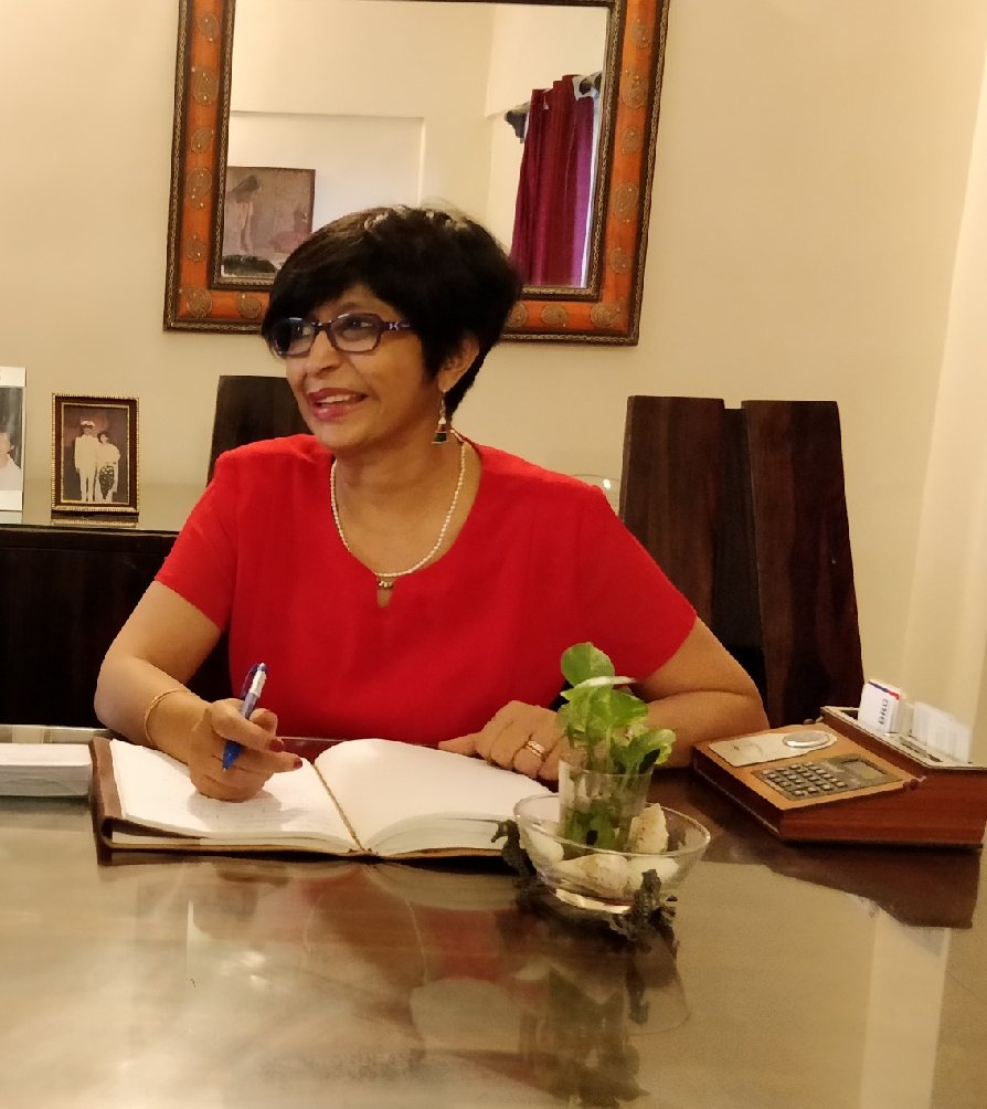 Ruth Singh at her desk, writing in a notebook